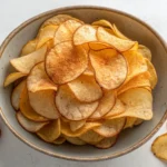 An overhead view of a bowl filled with golden, crispy tapioca chips