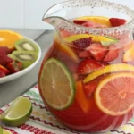 A pitcher of colorful bug juice with fruit slices.