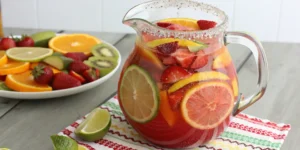 A pitcher of colorful bug juice with fruit slices.