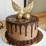 A Harry Potter-themed chocolate cake with a Golden Snitch, round glasses, and chocolate drip decorations.