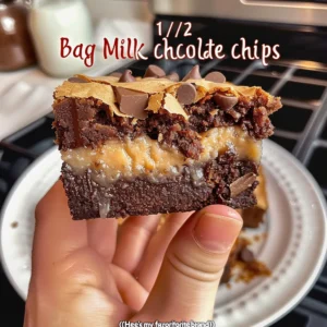 Sweetened condensed milk being poured over a pan of freshly baked crack brownies.