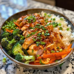 Close-up of a Bang Bang Chicken Bowl with rice, grilled chicken, avocado, roasted red peppers, and a creamy sauce.