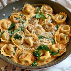Creamy tomato tortellini with mushrooms and spinach in a bowl.