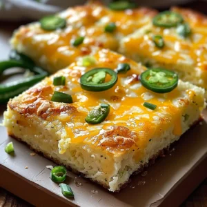 Four squares of jalapeño cheese cornbread on a wooden board.